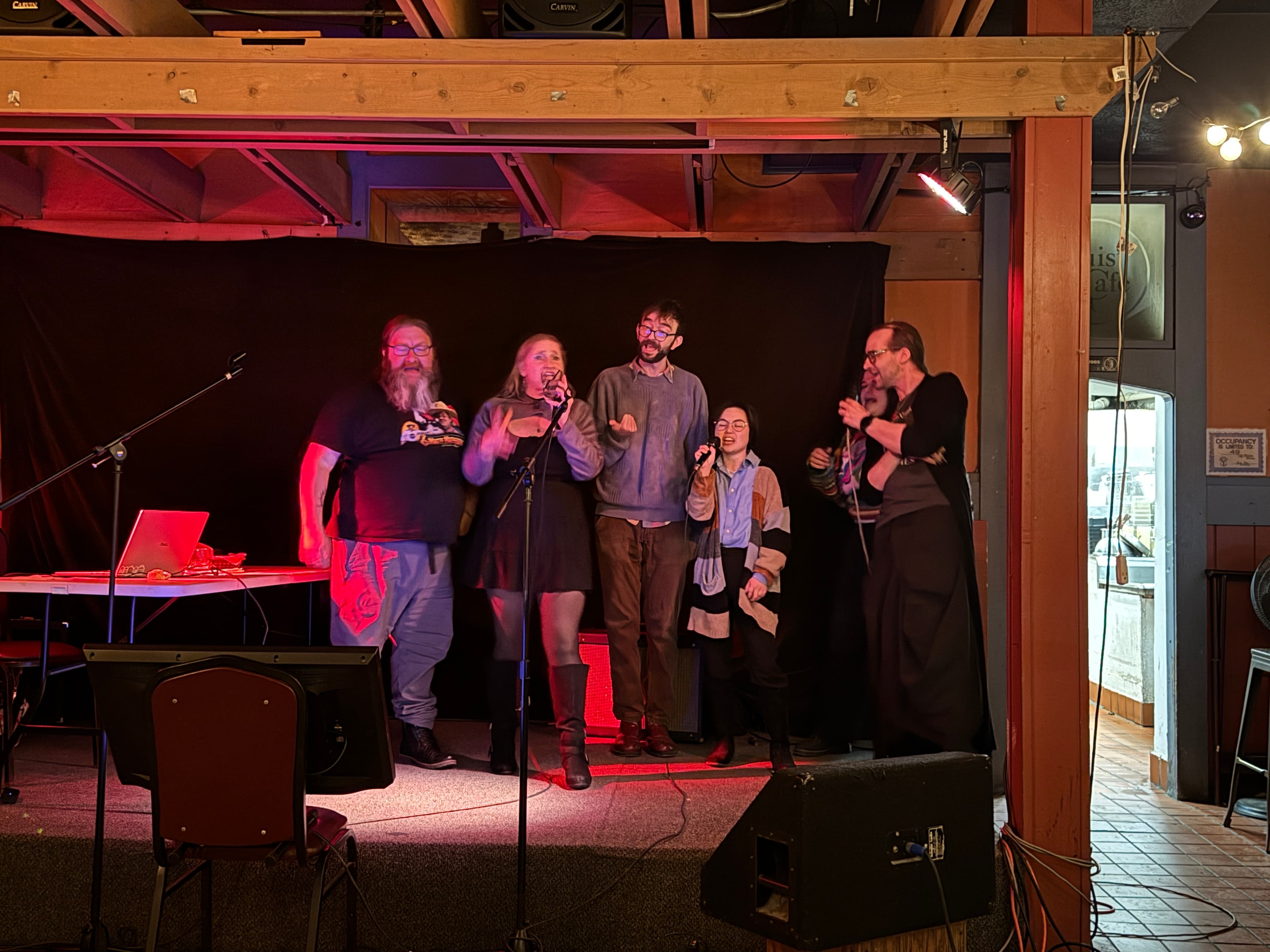 a group of people singing on stage.